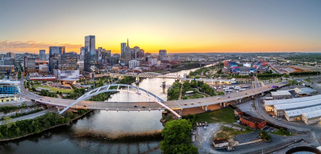 Downtown Nashville at sunset from above, the Cumberland River and the pedestrian bridge in the foreground