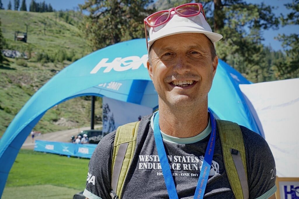 Craig Thornley, race director of the Western States 100, smiling outdoors in a Western States Endurance Run shirt